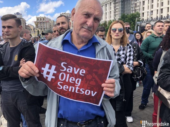 Люди держали плакаты #FreeSentsov и надписи 