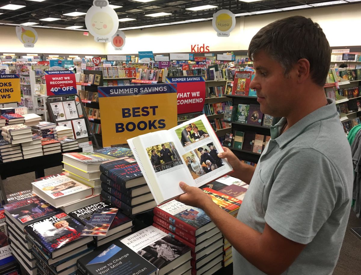 На фото прокурор демонстрирует американские книги, с полки 