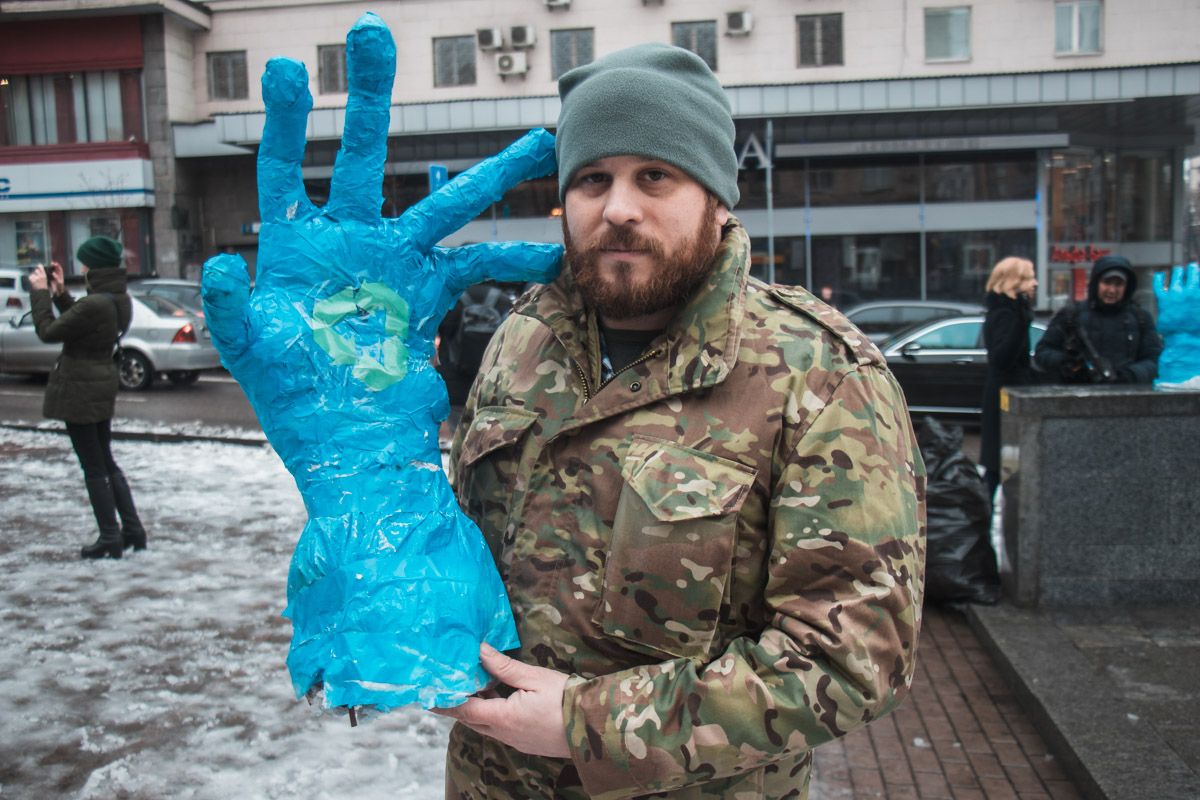 Синие руки символизируют перчатки, в которых сортируют мусор.