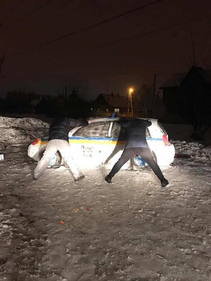 Авторы скульптуры позируют возле снежного 