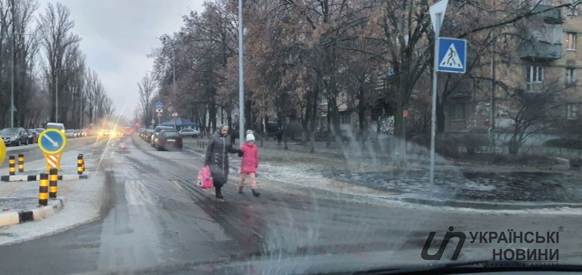 Люди идут по обочине. Там не скользко