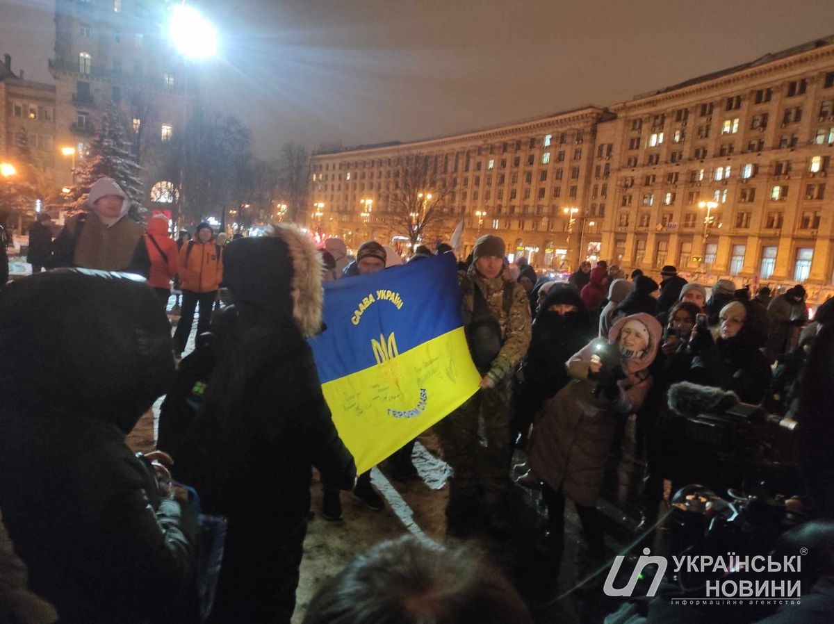 Військовий показує прапор України, підписаний Залужним