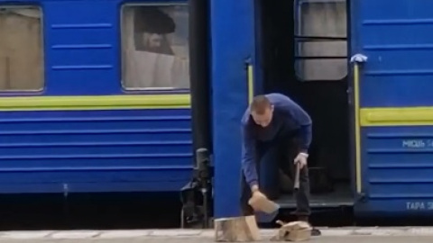 Провідник рубає дрова на пероні. Скріншот відео