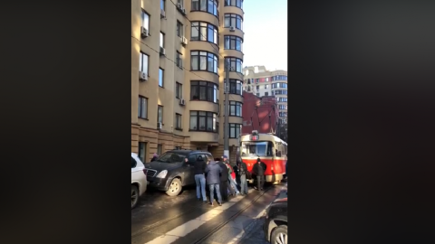 На відео чоловіки штовхають чорний позашляховик. Скріншот: "Блогерський Київ"/Facebook