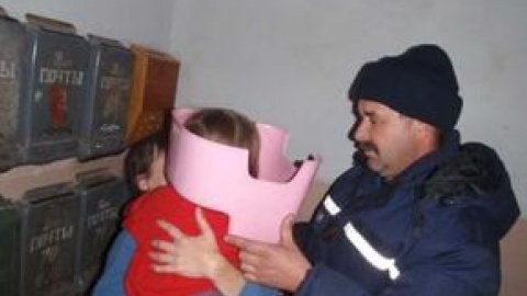 Дитина, граючись, засунула голову в рожевий пластиковий горщик.