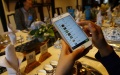 A tourist takes an order with a mobile phone app at a restaurant in Wuzhen, east China's Zhejiang Province. Photo by Xinhua/Rong Hao.