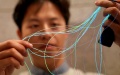 A researcher of Fudan University shows the illuminating fibers in Shanghai, east China. Photo by Xinhua/Liu Ying.