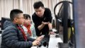 A teacher gives instructions as pupils operate computers after school at a primary school in Baoji, northwest China's Shaanxi province. Photo by Xinhua/Liu Xiao.