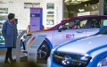 A prospective buyer looks at new energy vehicles at an advertising campaign in rural areas. Photo by Xinhua.

