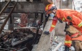A rescuer and a sniffer dog work at a gas explosion site in Yanhu Community of Zhangwan District in Shiyan City. Photo by Xinhua/Xiao Yijiu.