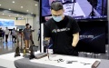 A staff member practices Chinese calligraphy by a bionic hand at the 2021 World Artificial Intelligence Conference in east China's Shanghai. Photo by Xinhua/Fang Zhe.