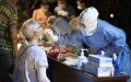 A medical worker takes a swab sample from a resident for COVID-19 nucleic acid testing at a residential community in Wuhan, central China's Hubei Province. Photo by Xinhua/Xiong Qi.