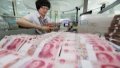 A clerk counts Chinese currency Renminbi (RMB) at a bank. Photo by Xinhua/Si Wei.