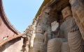 Tourists visit a stone Buddha in Tianti Mountain Grottoes in Wuwei City, northwest China's Gansu Province, on Aug. 20, 2021. Photo by Xinhua/Chen Bin.