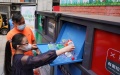 A child puts plastic bottles into the intelligent garbage bin of blue color at the Shaojiu residential community in Dongcheng District of Beijing, capital of China. Photo by Xinhua/Ju Huanzong.