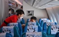A cabin crew member explains safety guidelines to a passenger. Photo by Xinhua/Wang Xi.