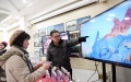 A staff member presenting a mobile game to a customer. Photo by Xinhua/Jin Liangkuai).