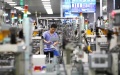 A staff member works at a workshop of microwave oven factory of Midea Group, a Chinese home appliance giant, in Foshan City, south China. Photo by Xinhua/Li Jiale.