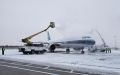 Ground crew members remove ice and snow covering a plane at Longjia airport in Changchun, northeast China's Jilin Province. Photo by Xinhua.