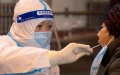 A medical worker takes a swab sample from a resident for nucleic acid testing at a sampling site in Harbin, Northeast China's Heilongjiang province. Photo by Xinhua.