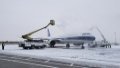 Ground crew members remove ice and snow covering a plane at Longjia airport in Changchun, northeast China's Jilin Province. Photo by Xinhua.