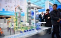 Visitors watch the model of a demonstration project for carbon dioxide capture, in an energy and chemical industry expo held in Yulin, northwest China's Shaanxi Province. Photo by Xinhua/Shao Rui.