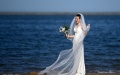 A woman in wedding dress pose for photos at an artificial beach resort at Dongjiang Port in the Binhai New Area of north China's Tianjin. Photo by Xinhua/Li Ran.