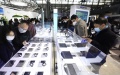 Visitors stop at a booth of wearable devices during the Mobile World Congress (MWC) Shanghai.  Photo by Xinhua/Fang Zhe.