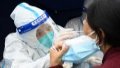 A medical worker takes a swab sample from a citizen for nucleic acid test at a testing site. Photo by Xinhua/Fan Peishen.