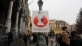 People walk past a poster of mandatory wearing of face masks in the Grand Place in Brussels, Belgium.  Photo by Xinhua/Zheng Huansong.