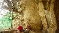 An archaeologist examining the face of a Buddha statue at the Fengxiansi Cave of Longmen Grottoes in central China's Henan Province. Photo by Xinhua.