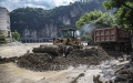 Workers remove mud after a flood in Wuxi County of Chongqing, southwest China. Photo by Xinhua/Huang Wei.