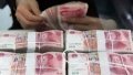 A worker counts Chinese currency Renminbi banknotes at a bank in Tancheng County of Linyi City, east China's Shandong Province. Photo by Xinhua/Zhang Chunlei.