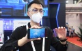 A staff member displays a mobile phone screen film that can generate 3D vision with phone applications. Photo by Xinhua/Ren Chao.