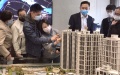 Potential homebuyers check models of housing projects at a real estate agency in Shanghai. Photo by Xinhua.