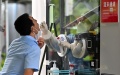 A medical worker takes a swab sample from a man for nucleic acid test in Sanya, south China's Hainan Province. Photo by Xinhua/Guo Cheng.