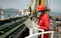 A worker from Petroleos de Venezuela operates machinery in front of the Fortune oil tanker, docked at the El Palito Refinery, Carabobo state, Venezuela. Photo by Xinhua/Marcos Salgado.