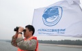A researcher uses a pair of binoculars to conduct monitoring work during a scientific expedition on Yangtze finless porpoises at the Shishou section of the Yangtze River, central China's Hubei Province. Photo by Xinhua/Xiao Yijiu.