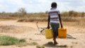 A boy carries buckets of water in Kidemu sub-location in Kilifi County, Kenya. Photo by Xinhua/Dong Jianghui.