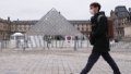 A man walks past the pyramid of Louvre Museum in Paris, France,. Photo by Xinhua/Gao Jing.