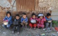 Palestinian children wait to receive charity meals at al-Zaitoun neighborhood in the east of Gaza City. Photo by Rizek Abdeljawad/Xinhua.