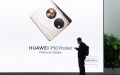 A man stands in front of a poster showing a Huawei's foldable cellphone during the Mobile World Congress in Barcelona, Spain. Photo by Gustavo Valiente/Xinhua.