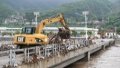 An excavator removes debris and litter from a bridge in Shuiyuzui Village in flood-hit Mentougou District, Beijing, capital of China. Photo by Xinhua/Ju Huanzong.