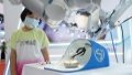A girl looks at a surgery robot during an expo of the World Robot Conference  in Beijing, capital of China. Photo by Xinhua/Ren Chao.