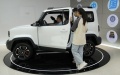 People learn about a new energy vehicle (NEV) at a sales outlet in Liuzhou City, south China's Guangxi Zhuang Autonomous Region. Photo by Xinhua/Guo Yifan.