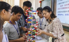 Преподаватель и ученики изучают модель структуры ДНК в средней школе уезда Синъе Гуанси-Чжуанского автономного района на юге Китая. Фото: Синьхуа/Цао Имин.