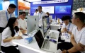 Visitors talk with exhibitors from an international trade software platform during the East China Fair in Shanghai, east China. Photo by Xinhua/Fang Zhe.