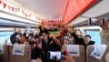 Passengers and crew members pose for group photos inside a train on the railway connecting north China's Tianjin Municipality with the Beijing Daxing International Airport. Photo by Xinhua/Li Ran.