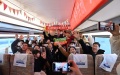 Passengers and crew members pose for group photos inside a train on the railway connecting north China's Tianjin Municipality with the Beijing Daxing International Airport. Photo by Xinhua/Li Ran.