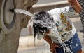 A boy refreshes himself with the water from the Barcaccia Fountain in the Piazza di Spagna in Rome, Italy. Photo by Xinhua/Jin Mamengni.